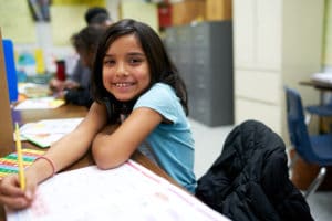 Children Rising student with reading workbook.