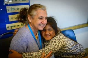 Child and Tutor share a laugh. Laughter is one of the benefits of volunteering.