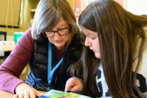 Jimena and Miss Karen reading through a book.