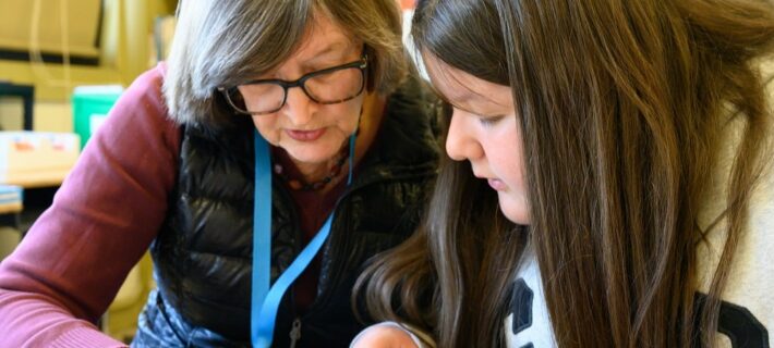 Jimena and Miss Karen reading through a book.