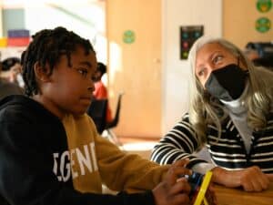 Audrey Amos provides homework tutoring to a child courtesy of funding from the Barrios Trust.